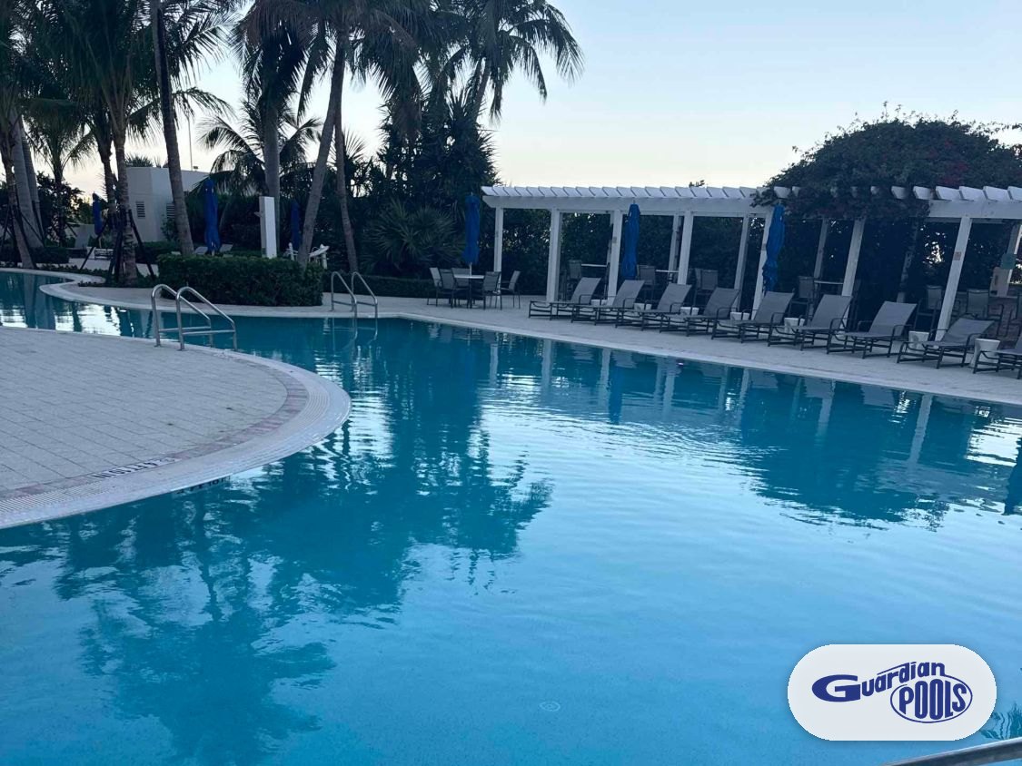 Newly resurfaced commercial pool in Pompano Beach with pergola and lounge chairs