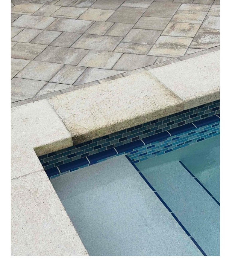 Pool coping with dark algae and mildew staining before a chemical cleaning